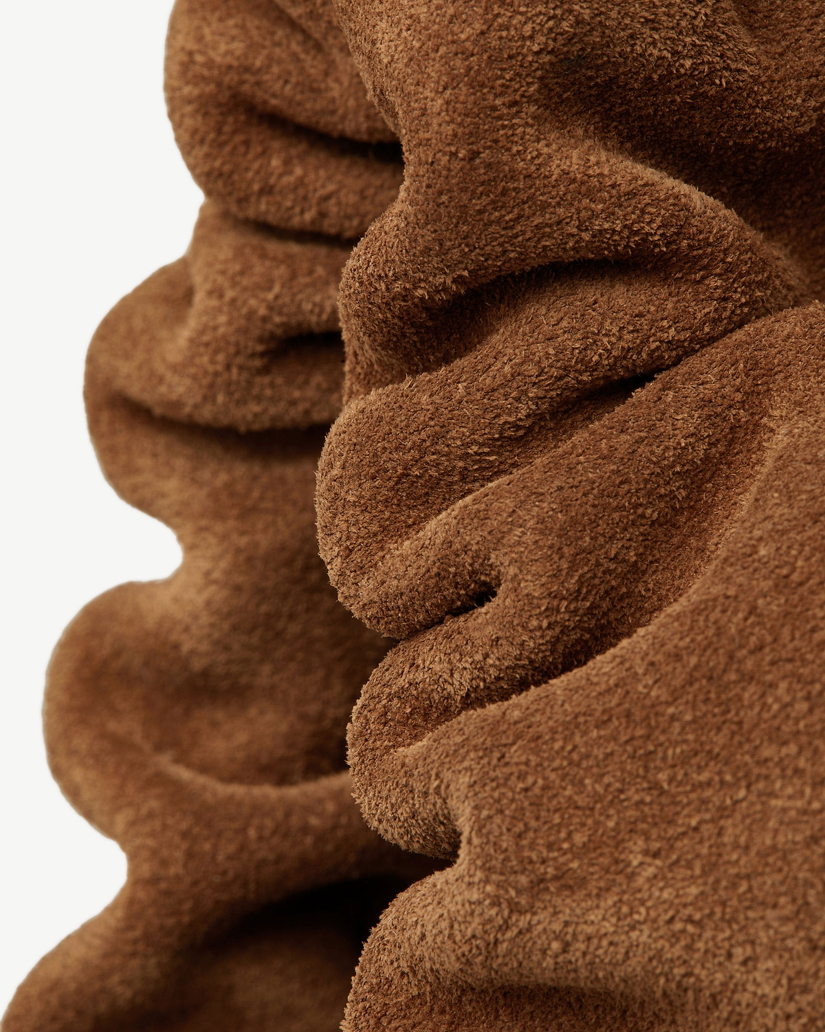 Tan suede drawstring bag ruffle showing soft textured suede nap and folds.