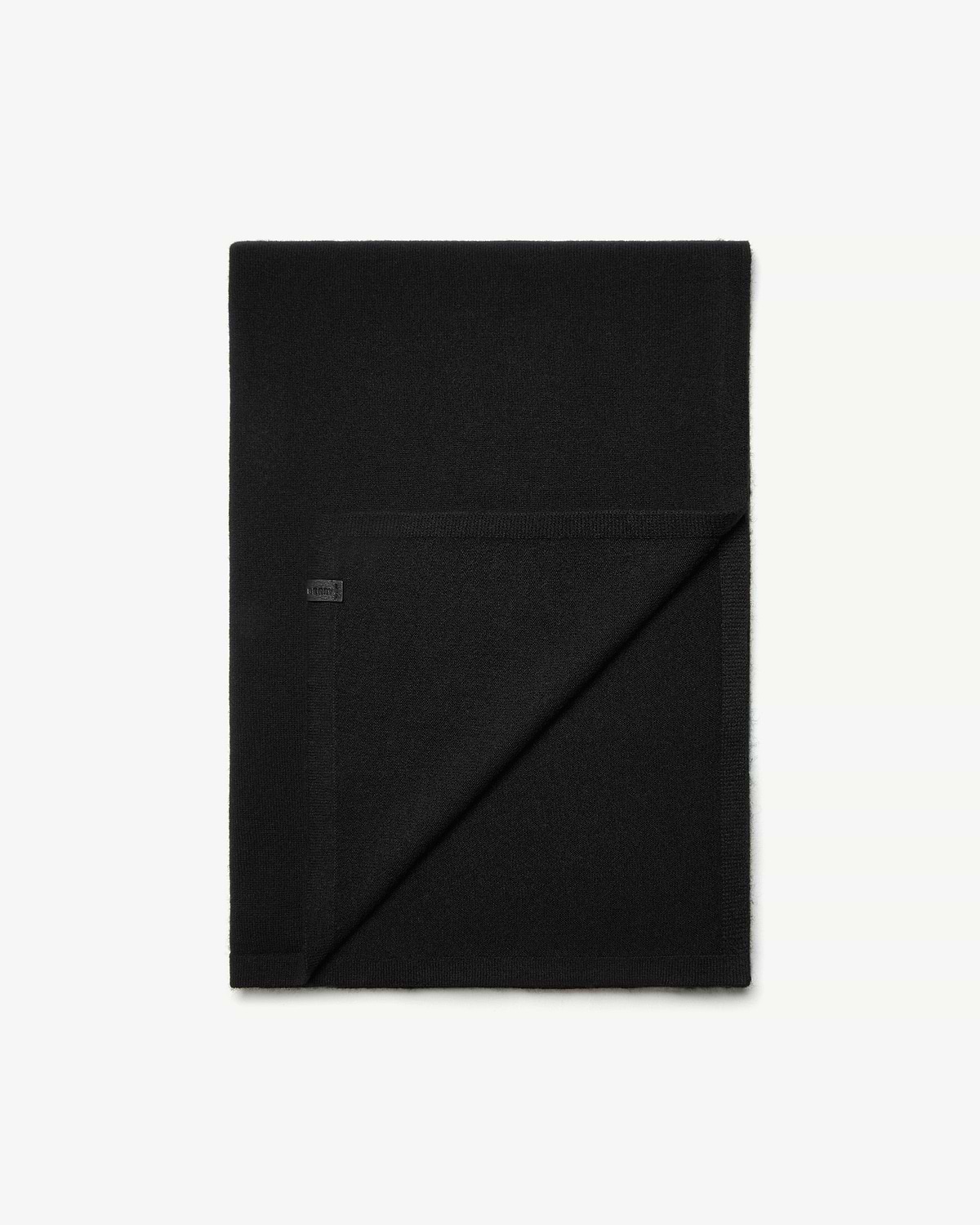 Black cashmere travel wrap folded, one corner turned to show the reverse side.