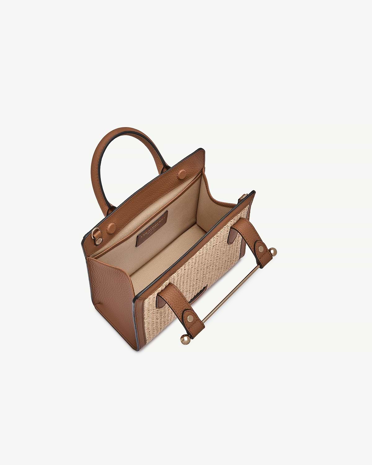 Tan leather mini tote with natural raffia panels, open top and interior pocket.