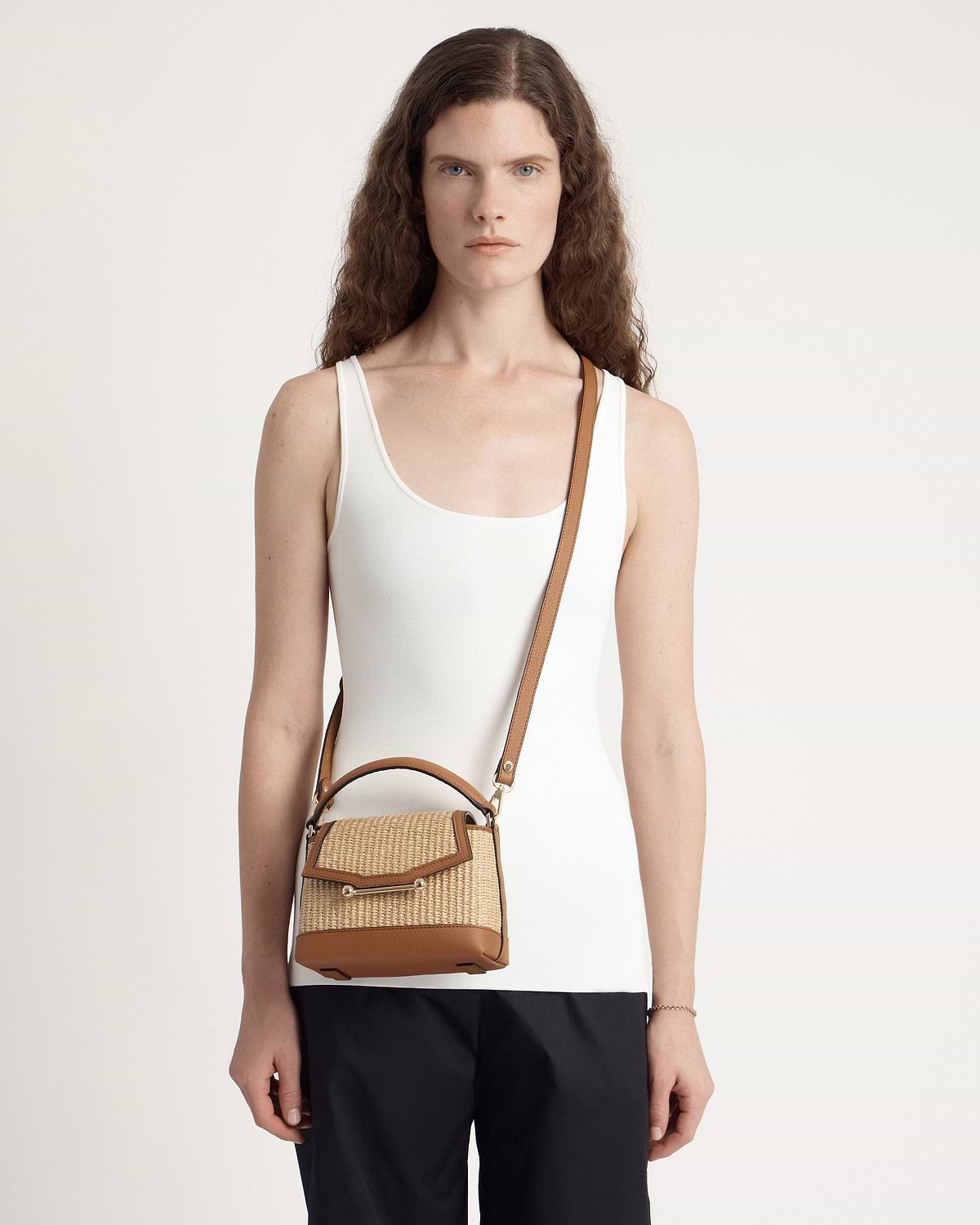 Model wearing tan and natural raffia Mosaic Nano crossbody bag with leather trim