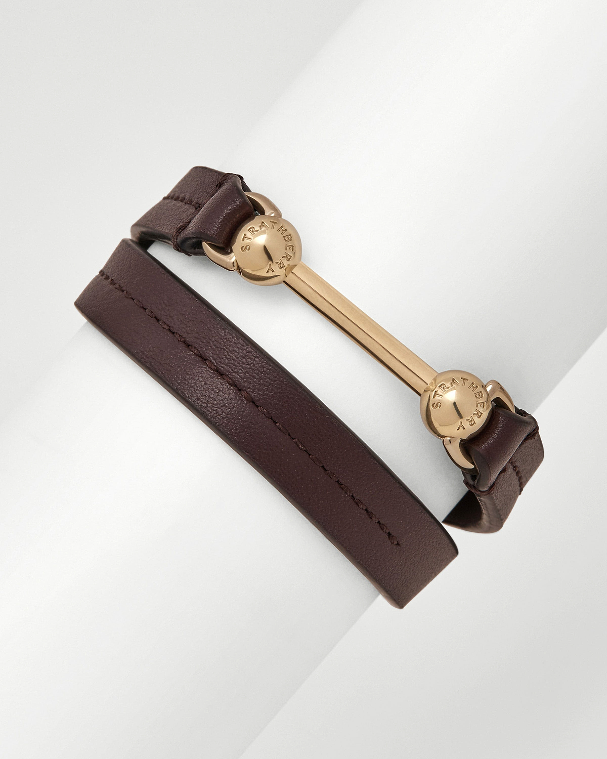Burgundy leather double-wrap bracelet with gold Strathberry bar and logo discs.