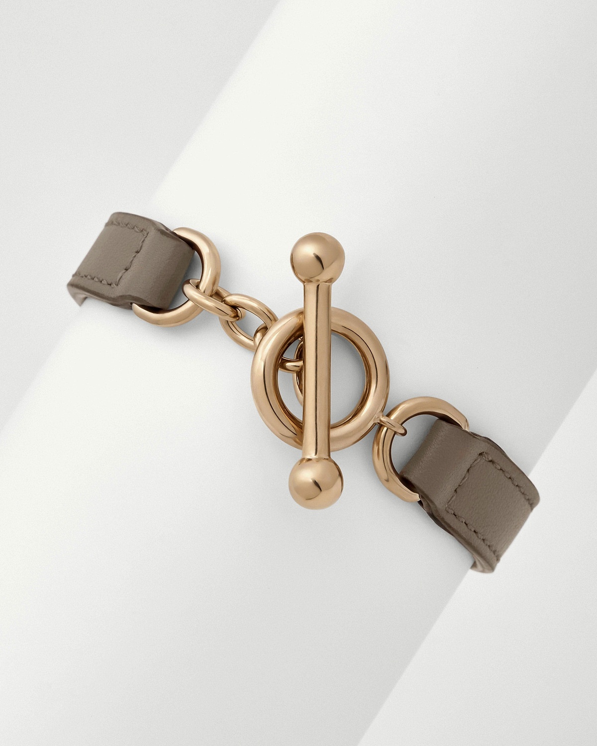 Taupe leather kite bracelet with gold tone circular toggle clasp