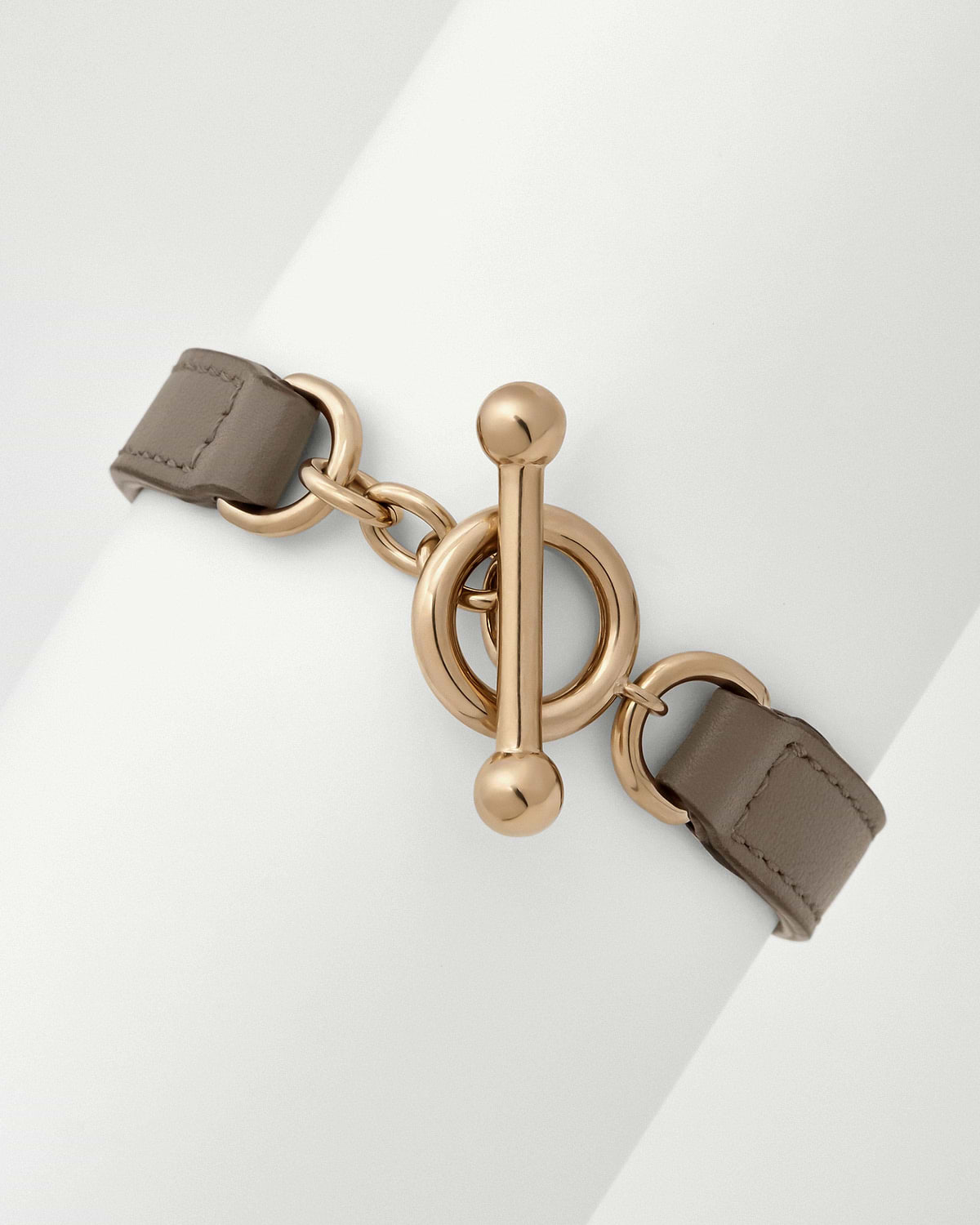 Taupe leather kite bracelet with gold tone circular toggle clasp
