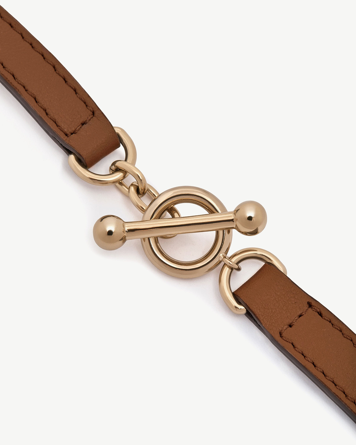 Tan leather kite bracelet with gold-tone circular toggle clasp hardware.