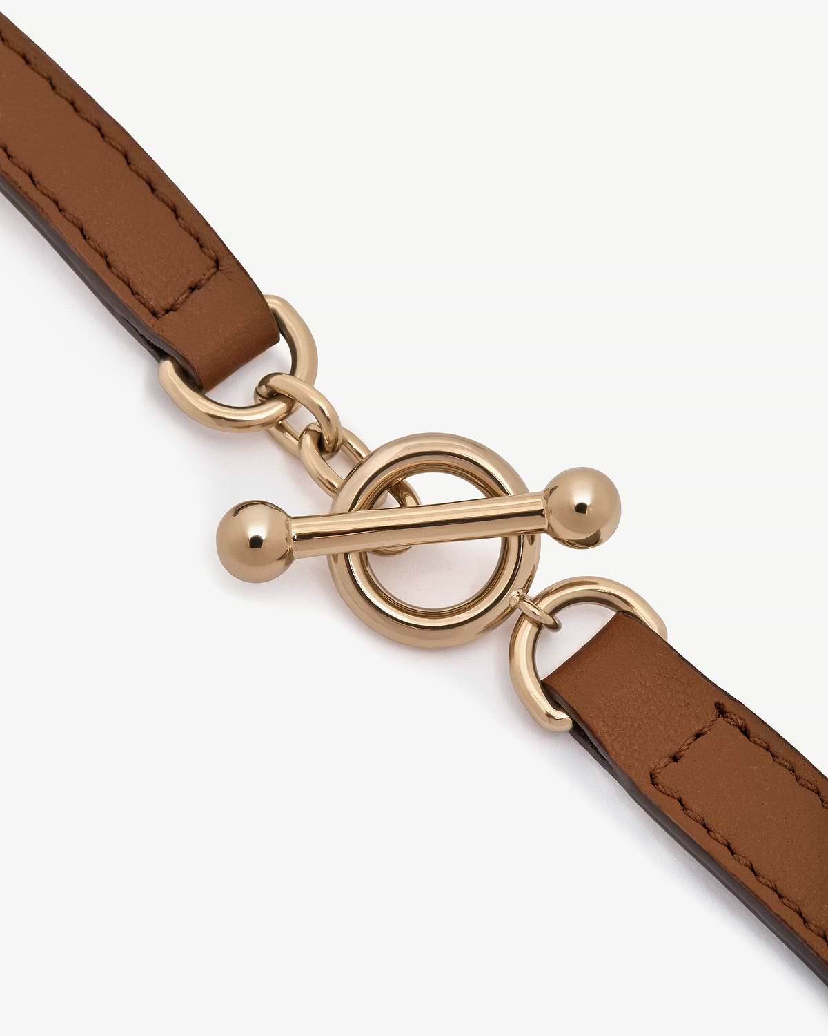 Tan leather kite bracelet with gold-tone circular toggle clasp hardware.