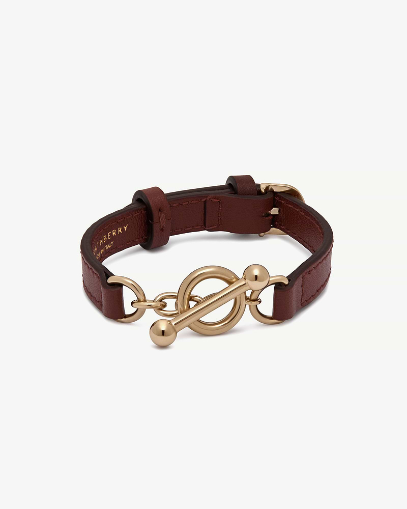 Oxblood leather kite bracelet with gold-tone toggle clasp and adjustable strap.