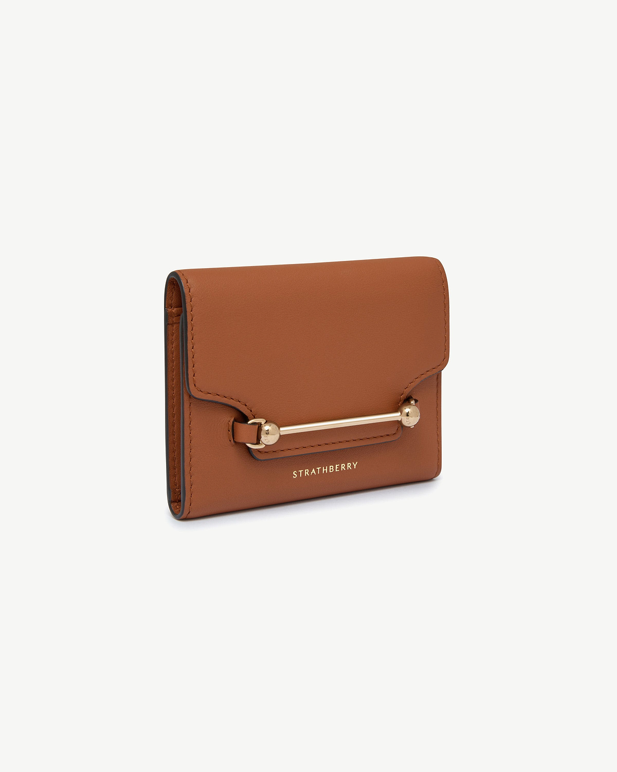 Strathberry chestnut trifold wallet with gold bar fastener on white background.