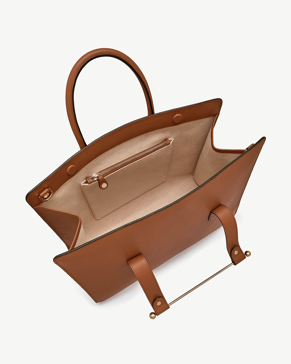 Chestnut leather tote bag open showing beige suede interior and zip pocket.