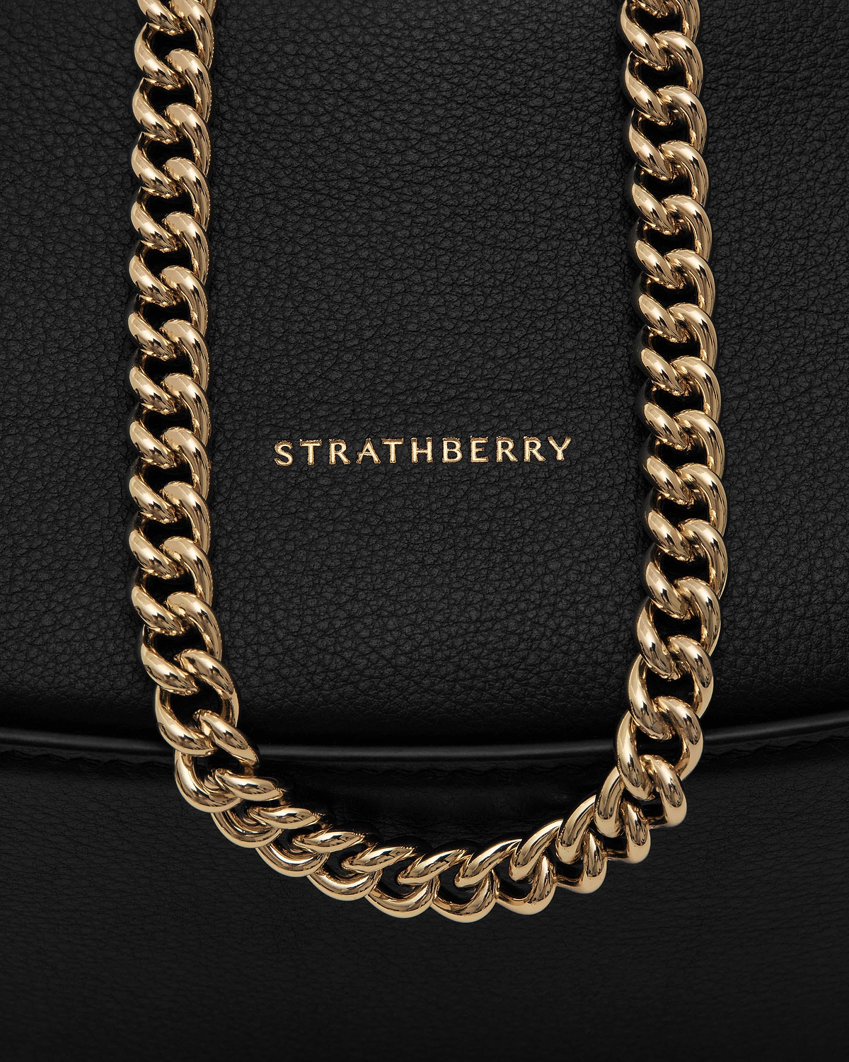 Black pebbled leather with Strathberry logo and gold chain strap detail.