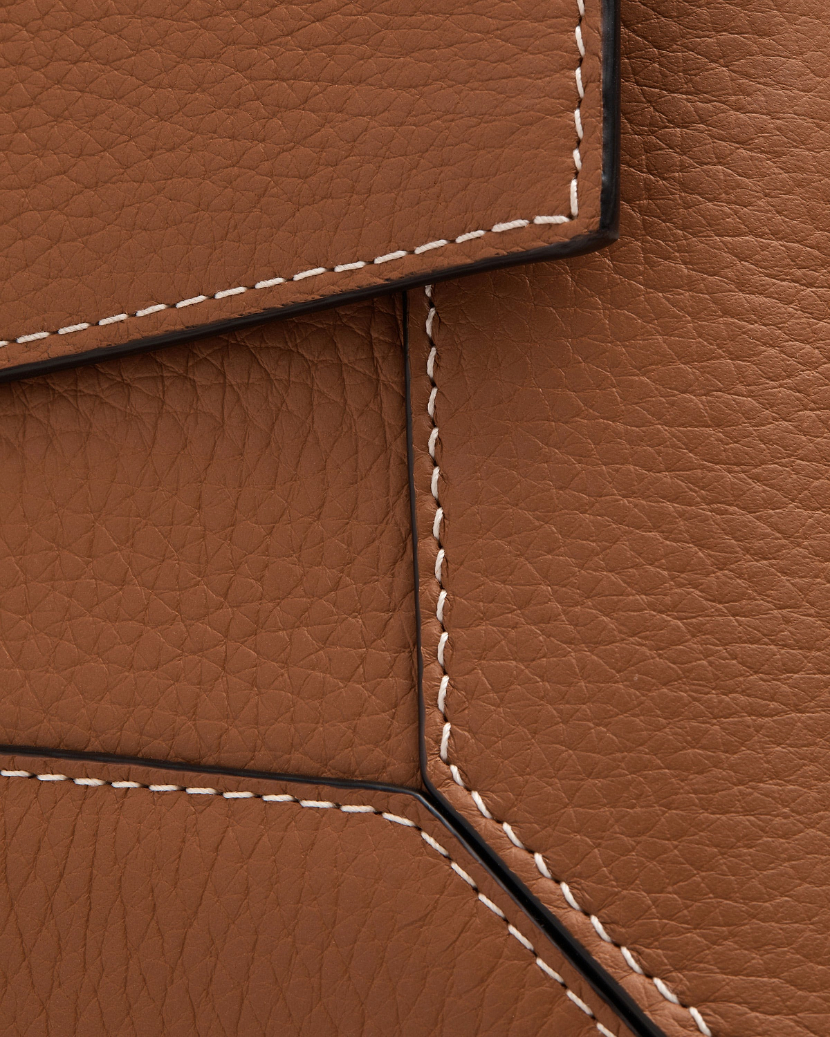 Tan leather mosaic shoulder close-up showing white stitching and pebbled texture.