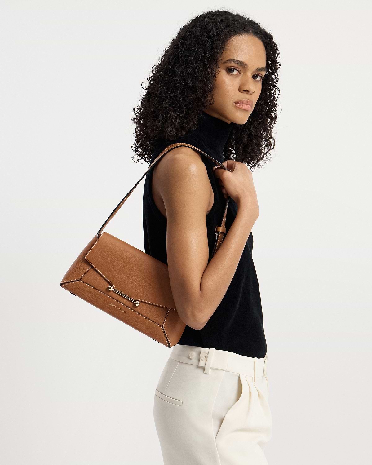 Model carrying tan Strathberry Mosaic Shoulder bag on her shoulder.