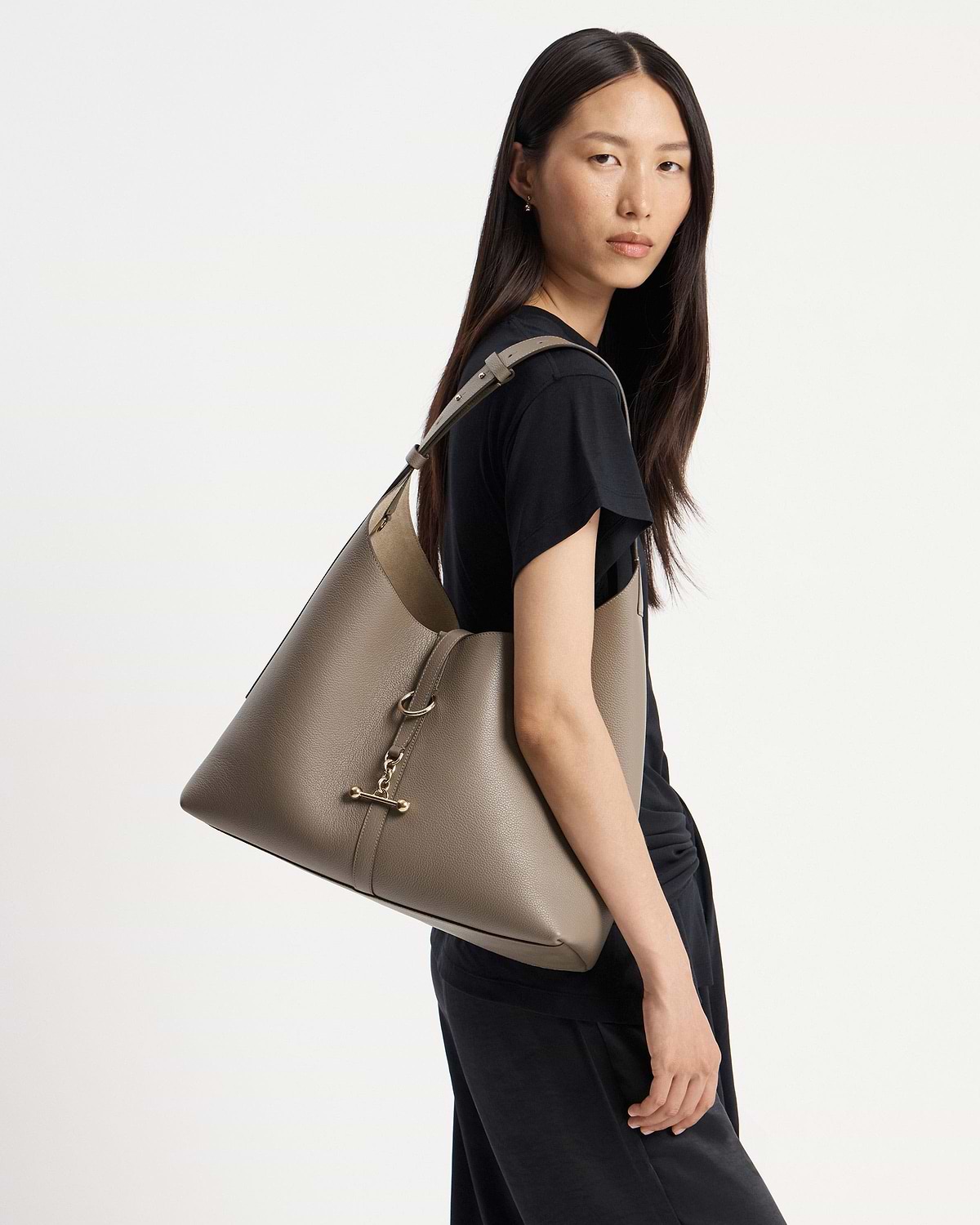 Model wearing a taupe Kite Hobo Maxi bag over her shoulder.
