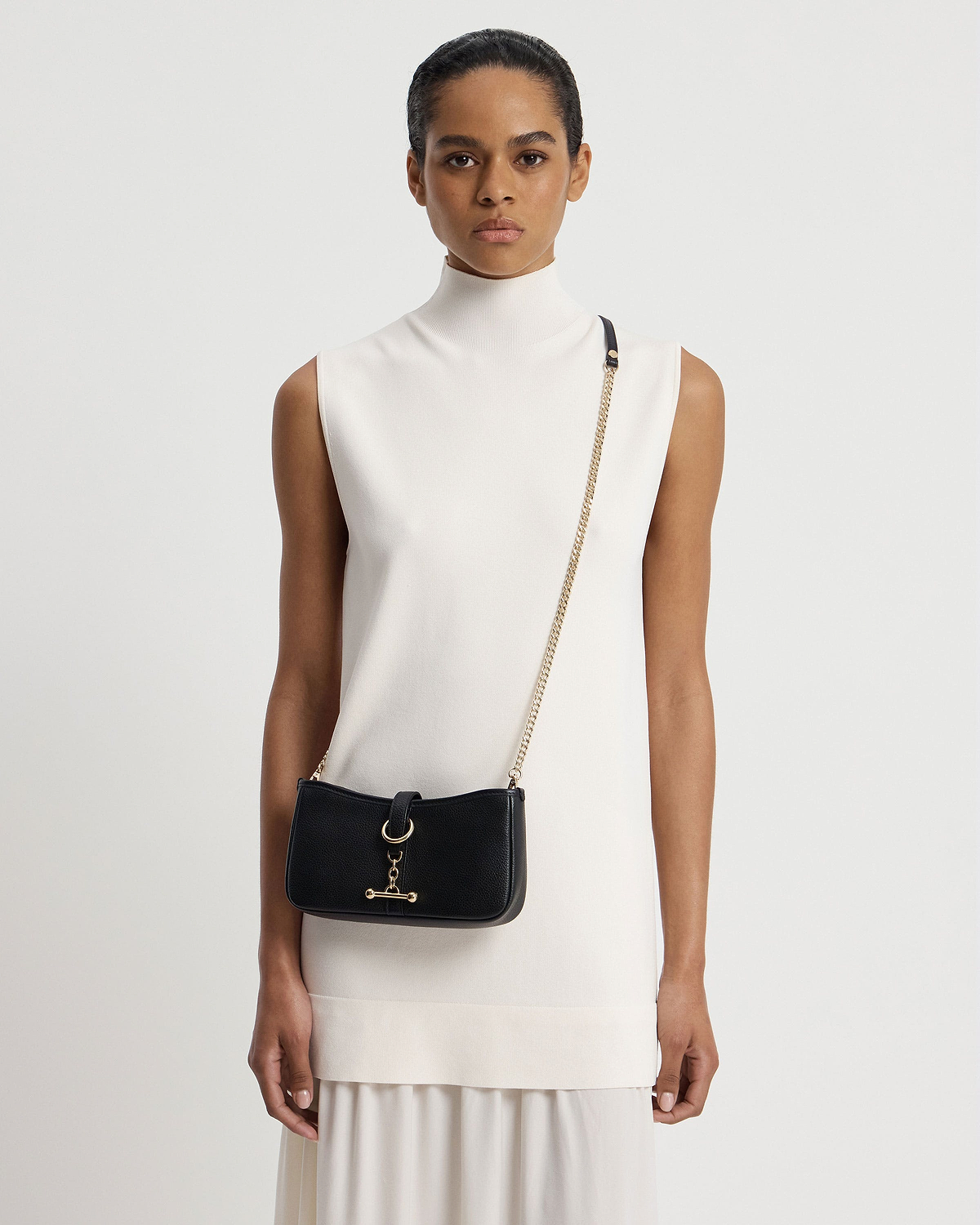 Woman wearing black Kite on a Chain bag with gold chain strap