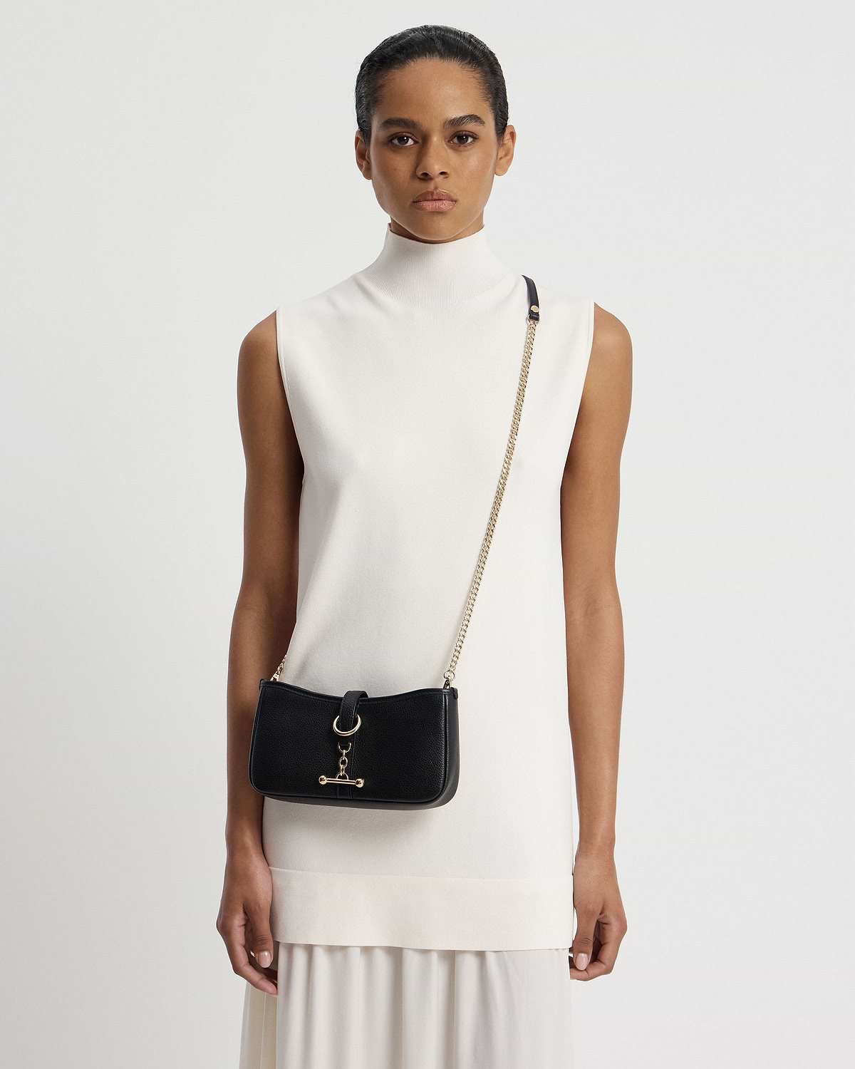 Woman wearing black Kite on a Chain bag with gold chain strap