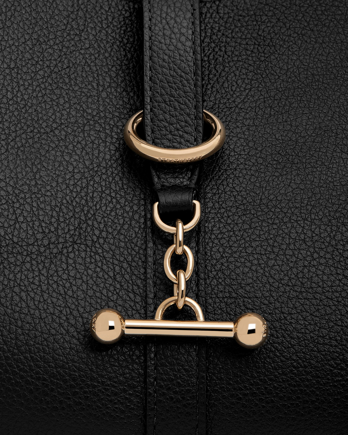 Black pebbled leather with gold Strathberry bar toggle fastening and chain detail