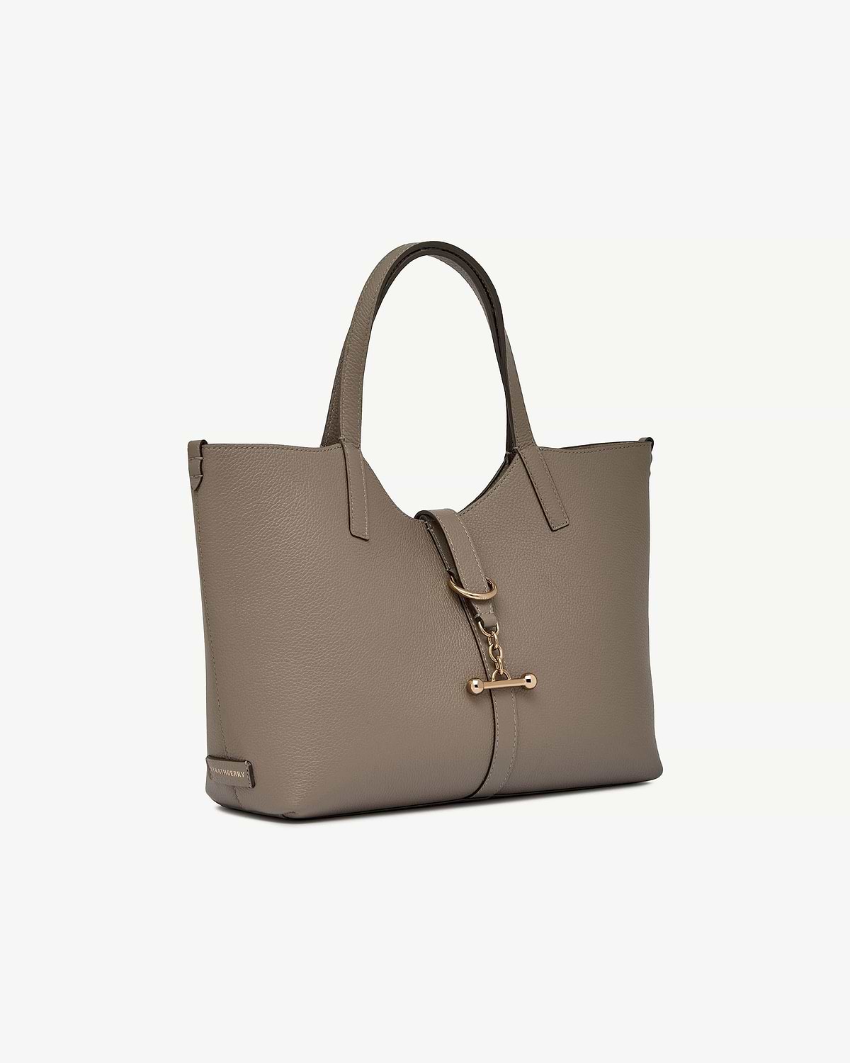 Taupe leather tote bag with top handles and gold bar strap closure.