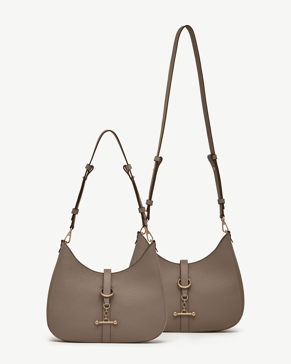 Two taupe kite sling bags with adjustable long and short straps and gold hardware.