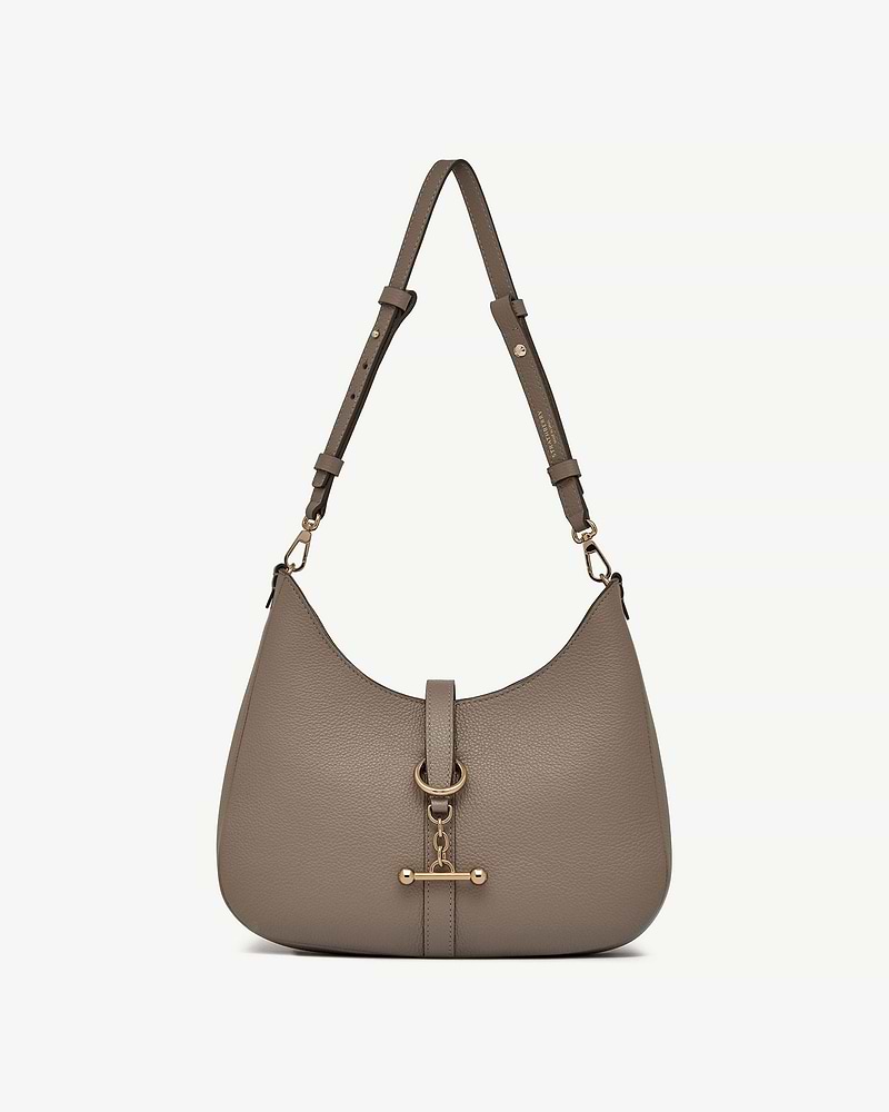 Taupe pebbled leather kite sling bag with adjustable strap and gold bar hardware.