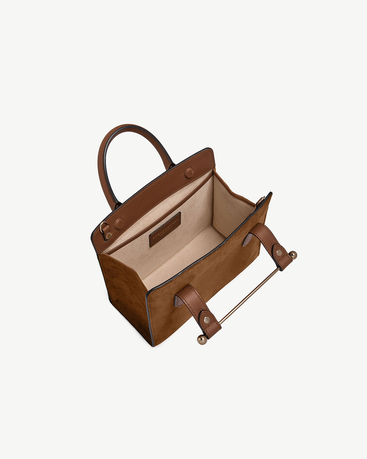 Tan suede mini tote open with leather handles, beige interior and Strathberry label.