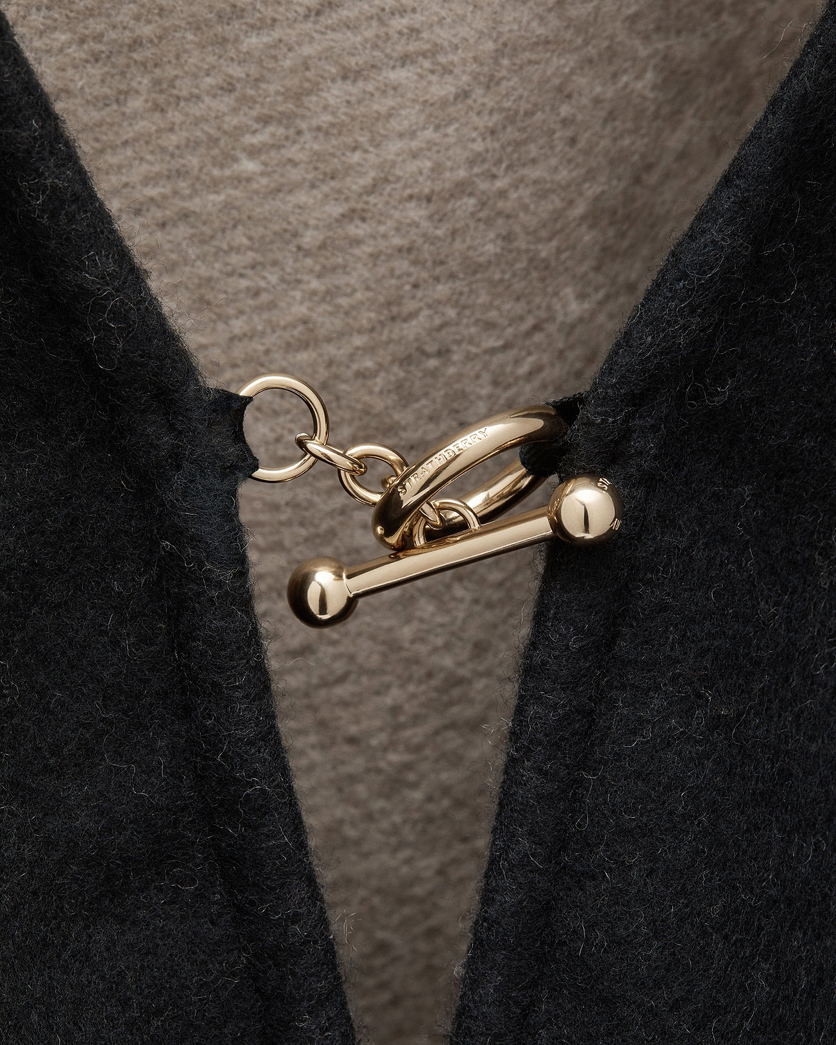 Otter lining and black woven cape with gold Strathberry toggle clasp