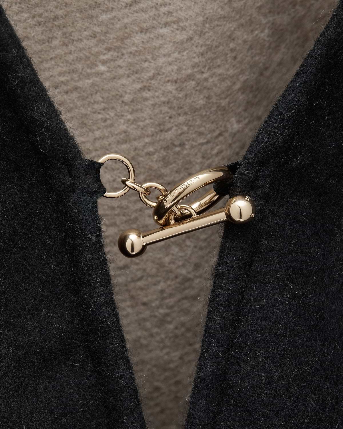 Otter lining and black woven cape with gold Strathberry toggle clasp
