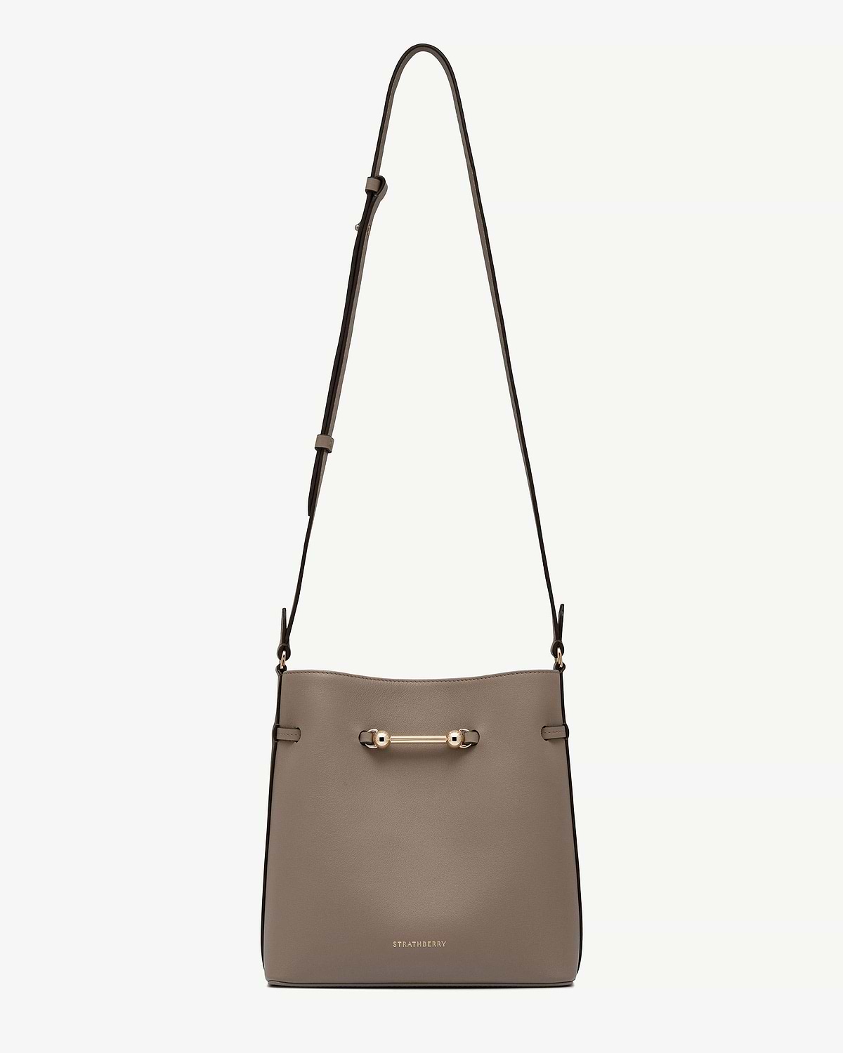 Taupe Corda bucket bag with adjustable strap, gold bar hardware and Strathberry logo.
