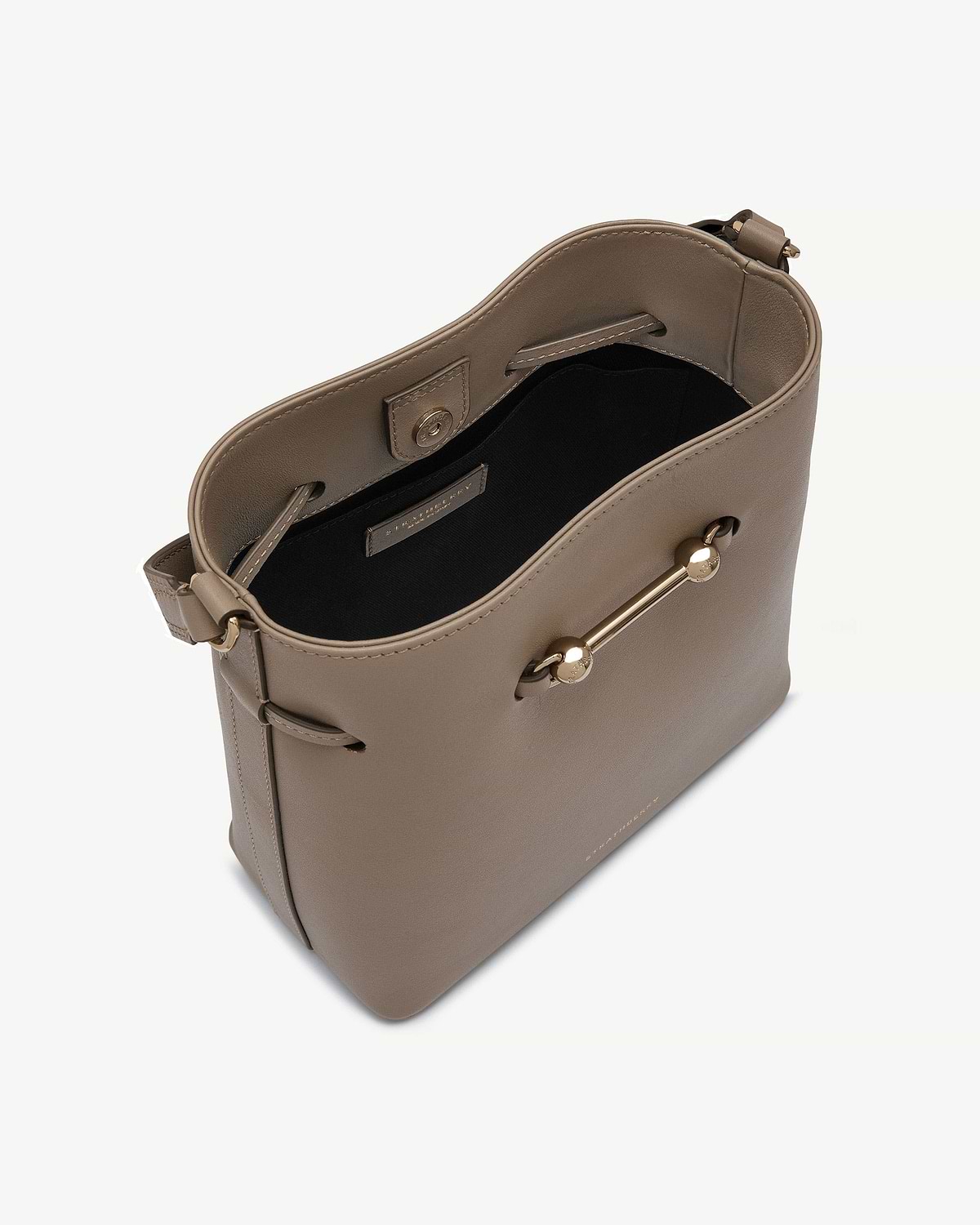 Taupe leather bucket bag with gold bar detail and black interior.