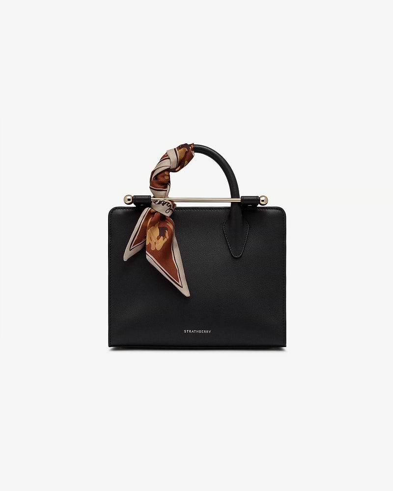 Sand and oxblood pop flowers silk skinny scarf tied to Strathberry handbag handle.