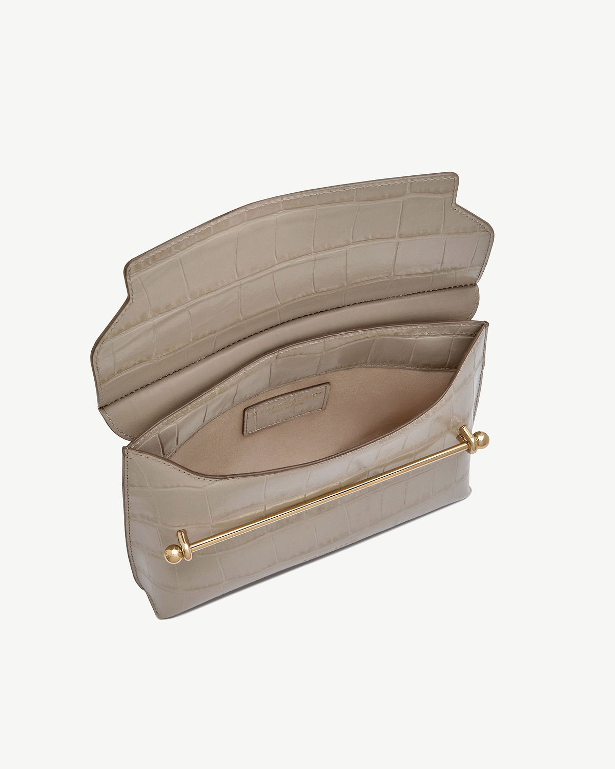Strathberry Stylist croc-embossed bag open, showing interior pockets and gold bar.