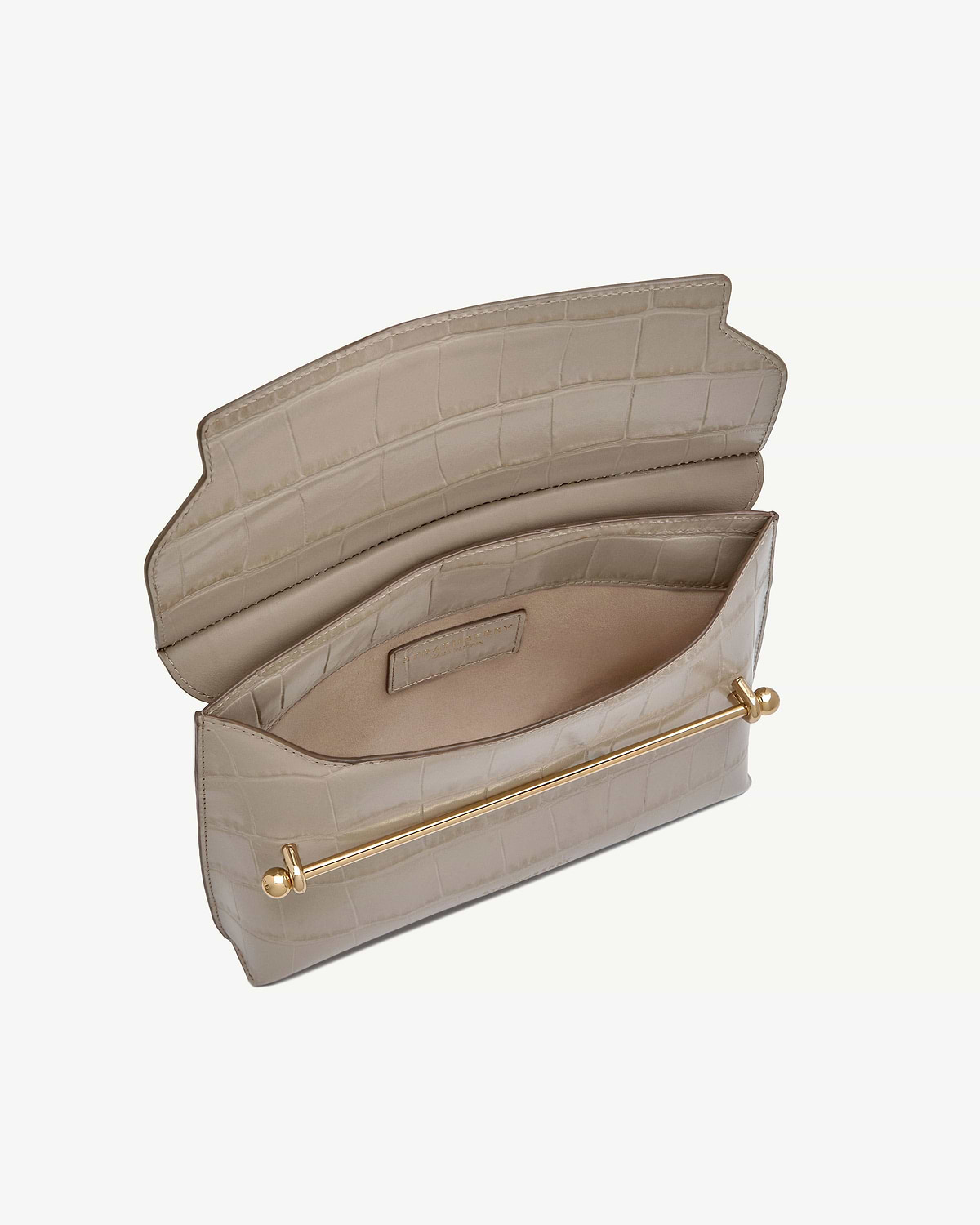 Strathberry Stylist croc-embossed bag open, showing interior pockets and gold bar.