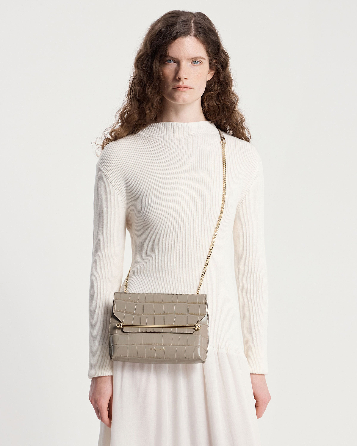 Model wearing cream ribbed top and taupe croc-effect stylist crossbody bag with gold chain strap