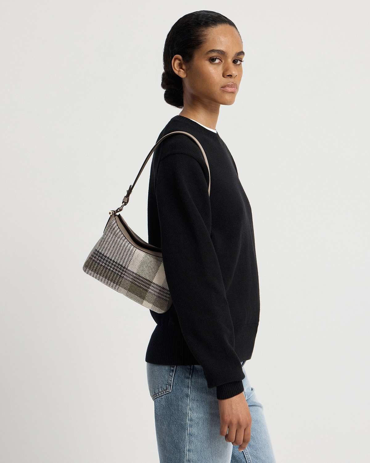 Model wearing Sway shoulder bag in tartan taupe, side view, shoulder strap visible.