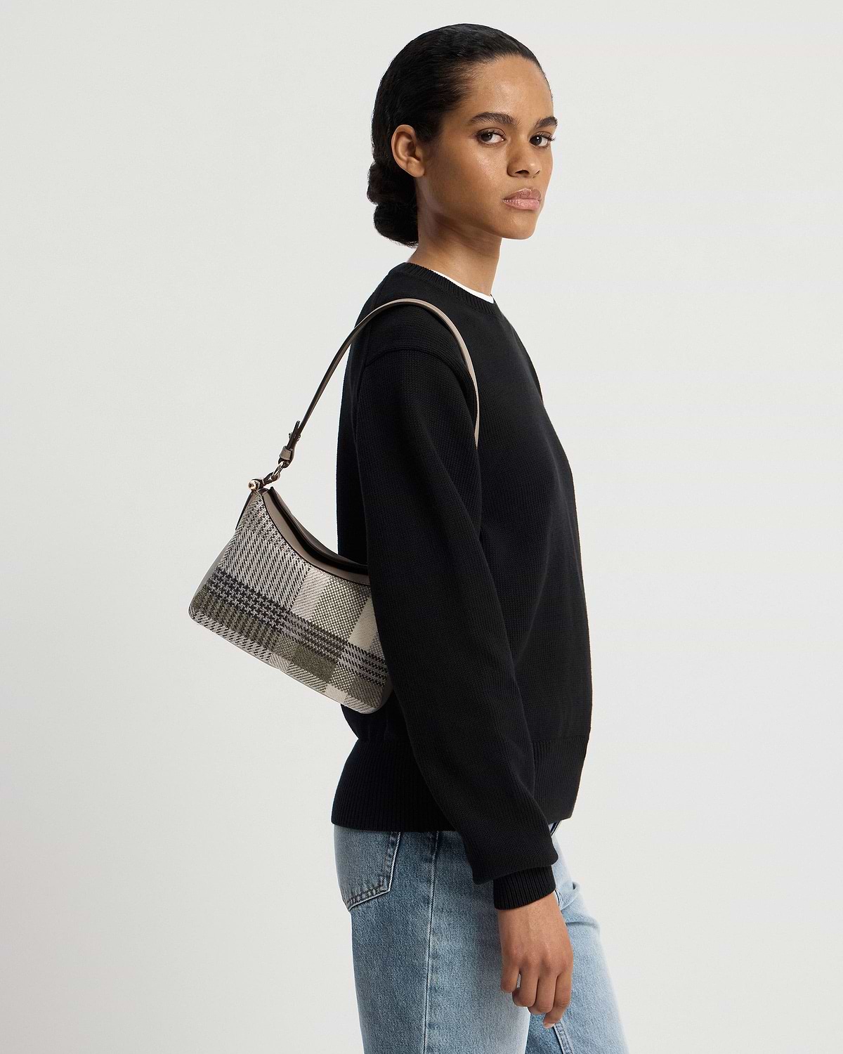 Model wearing Sway shoulder bag in tartan taupe, side view, shoulder strap visible.