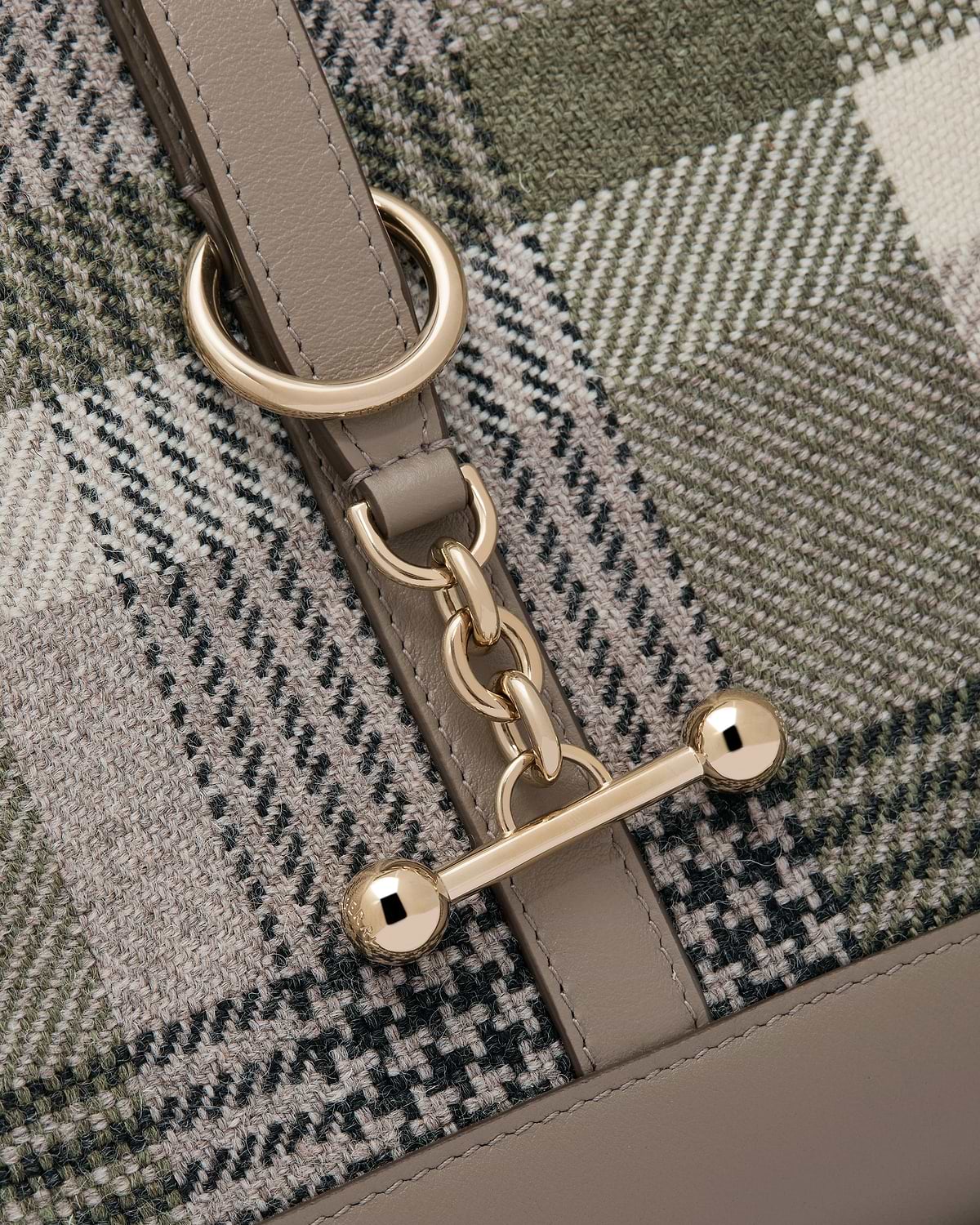 Tartan woven panel and taupe leather strap with gold chain and bar fastening.