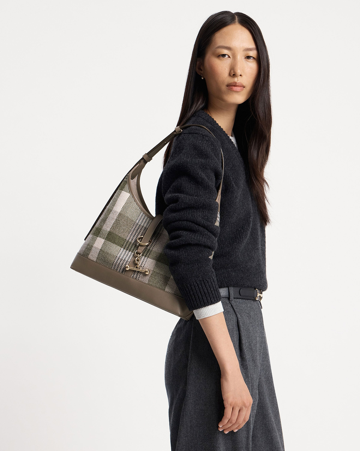 Model wearing checked tartan shoulder hobo bag with taupe leather trim.