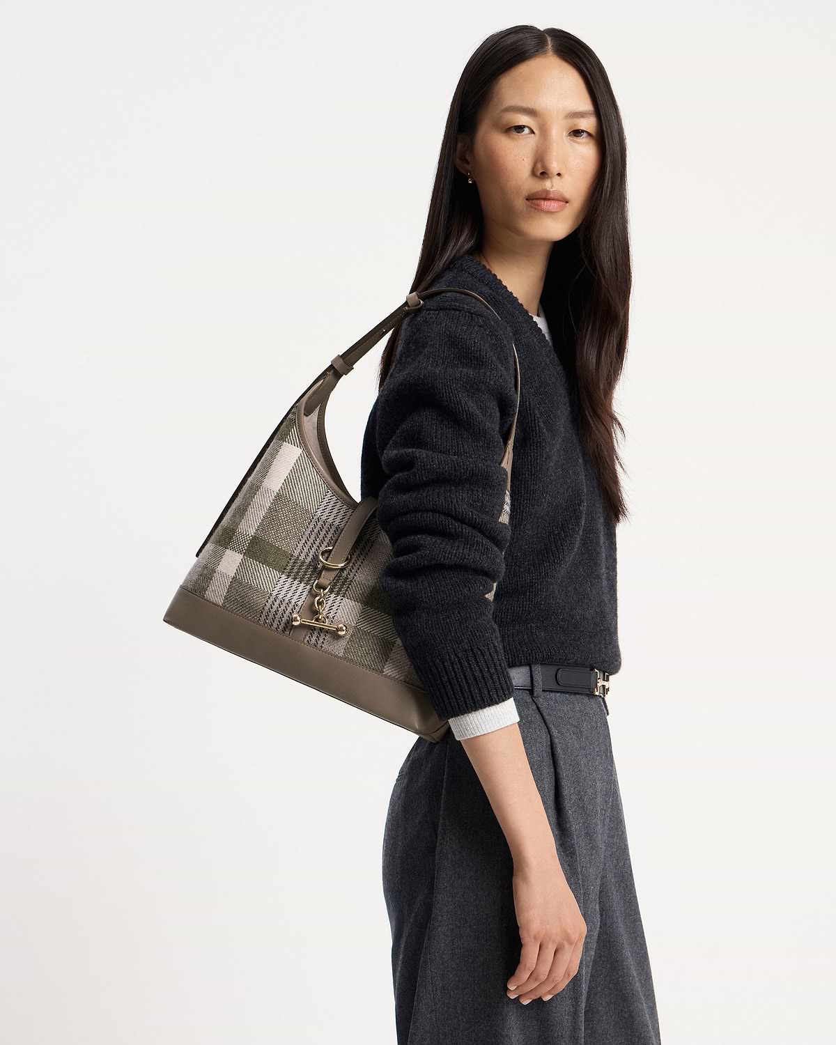 Model wearing checked tartan shoulder hobo bag with taupe leather trim.