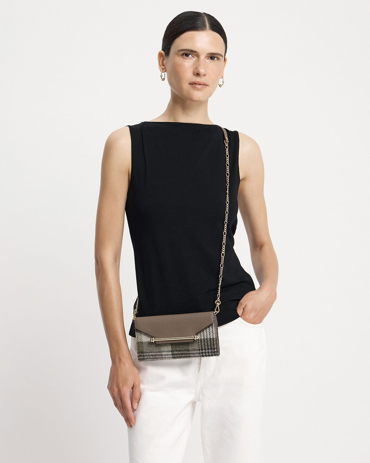 Model wearing black top with tartan taupe chain wallet worn crossbody at hip.