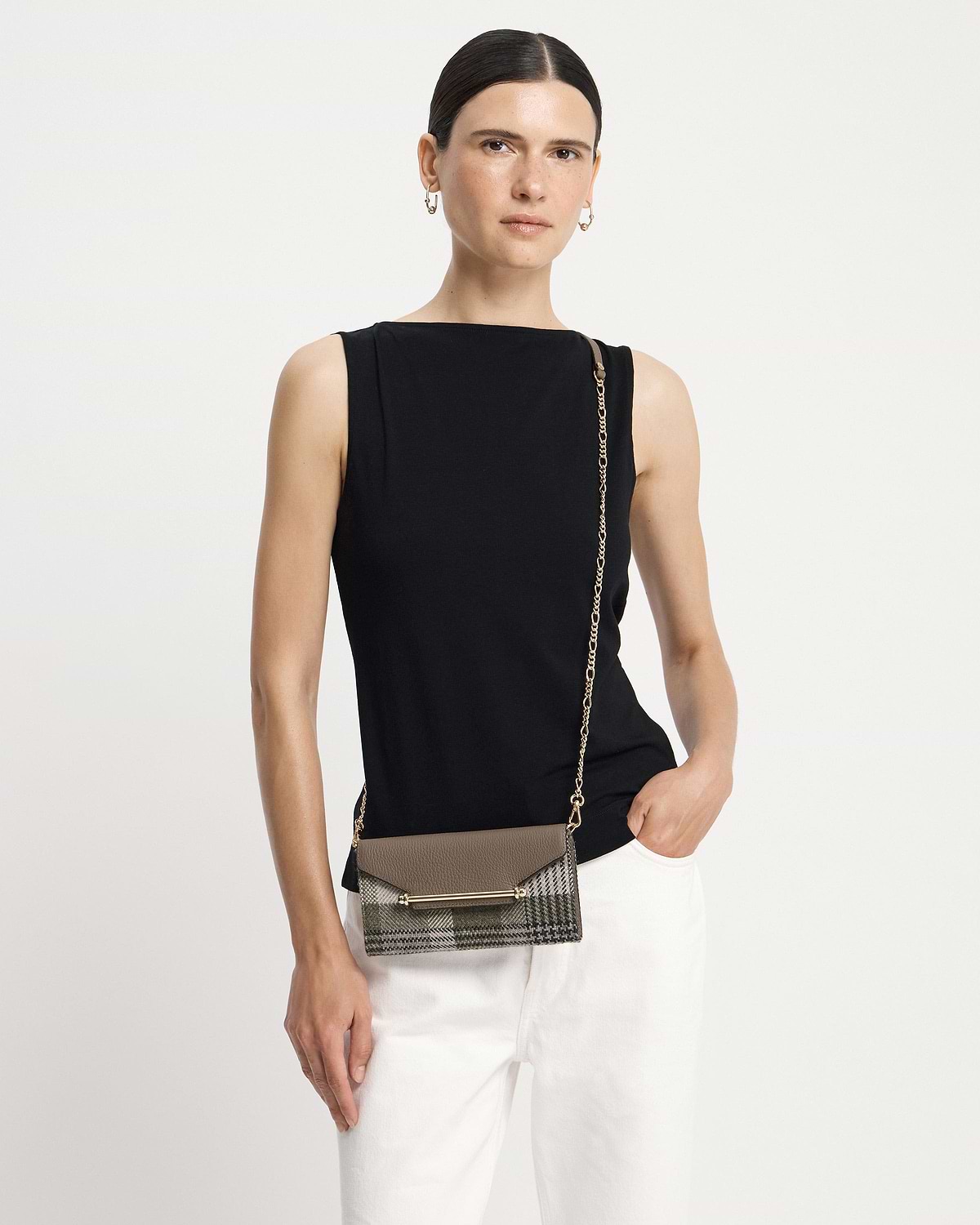Model wearing black top with tartan taupe chain wallet worn crossbody at hip.