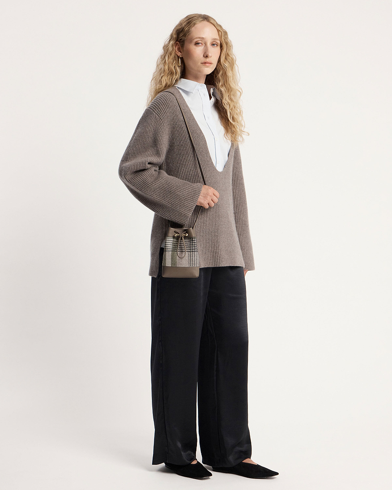 Woman wearing taupe ribbed jumper and tartan taupe midi pouch cross-body.