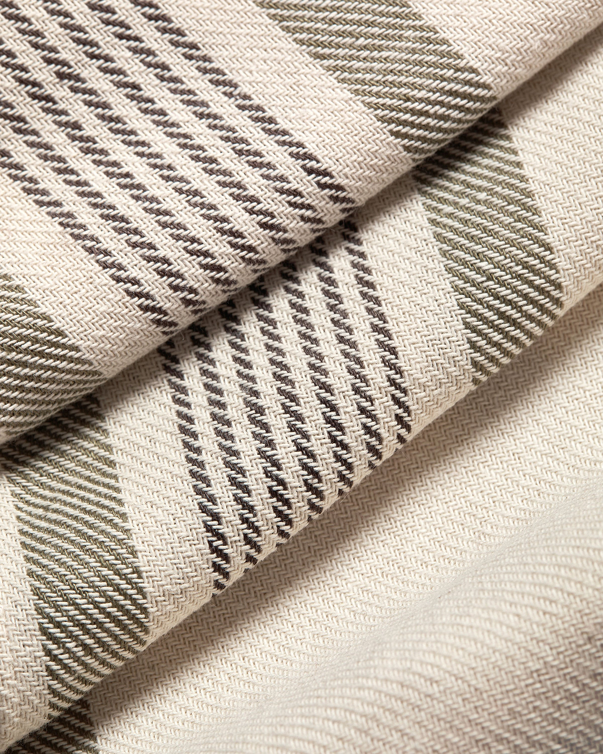 Folded cream tartan cotton linen table runner with brown and olive stripes.