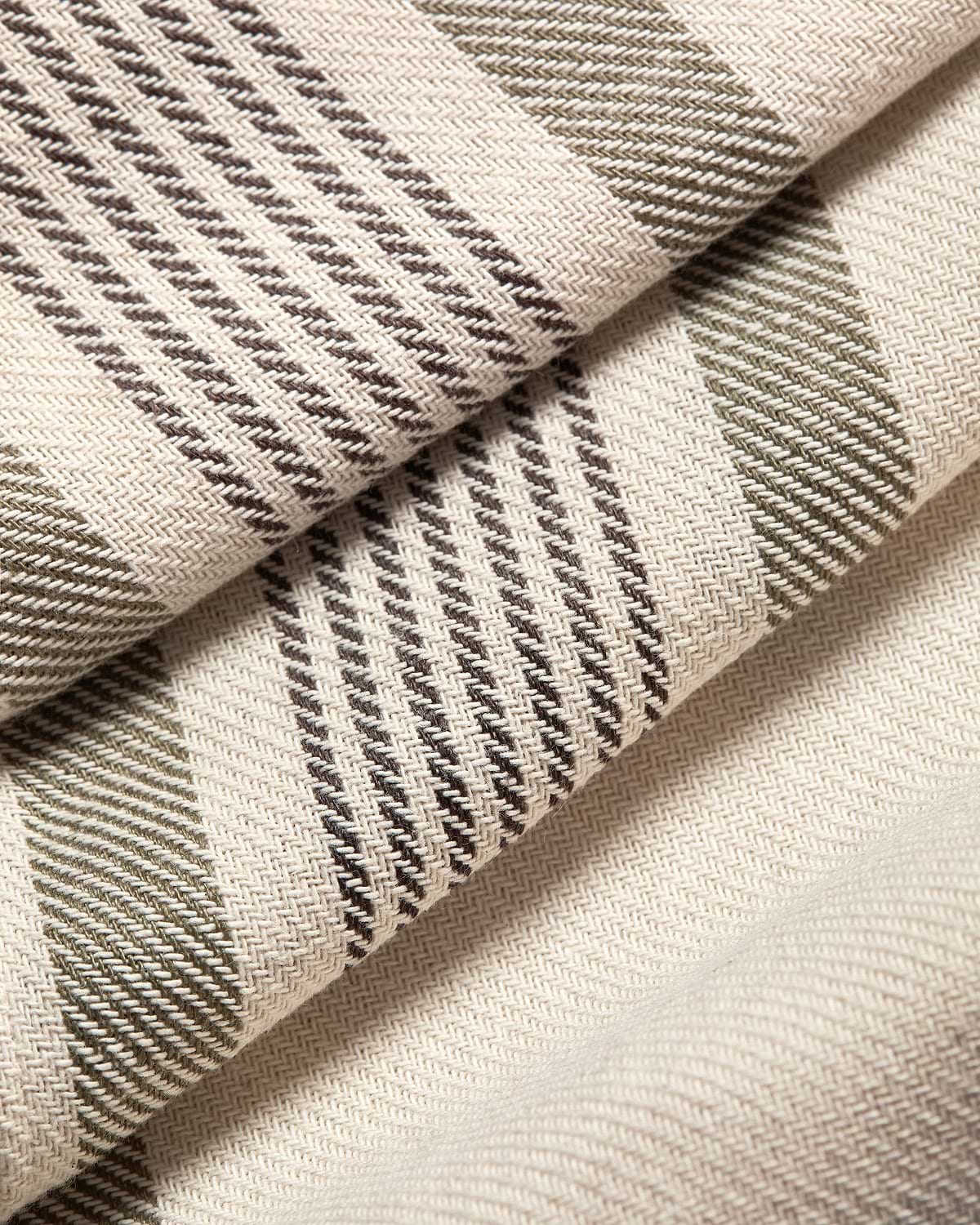 Folded cream tartan cotton linen table runner with brown and olive stripes.