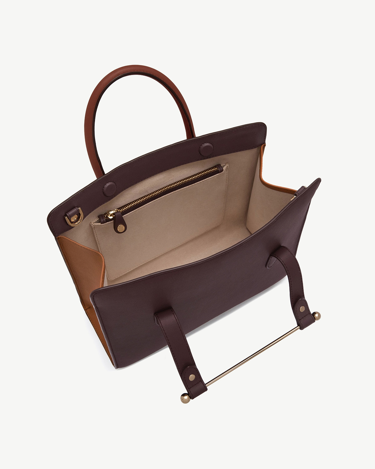 Open burgundy and chestnut midi tote showing beige interior and zipped pocket.