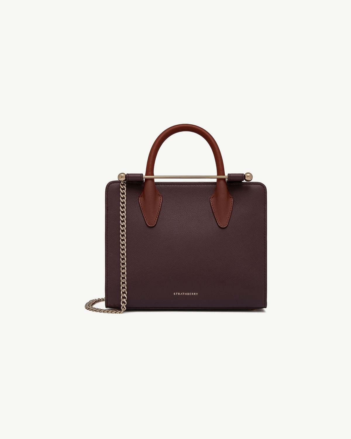 Strathberry burgundy mini tote with chestnut handles and gold chain strap.