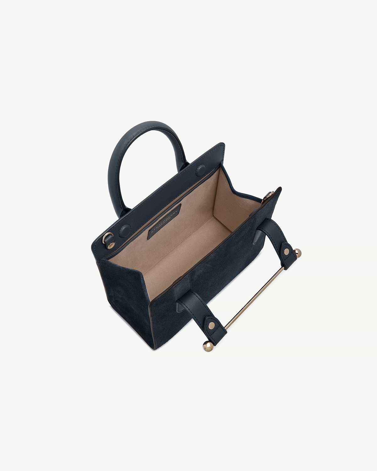 Navy suede mini tote showing beige interior, top handles and gold hardware.