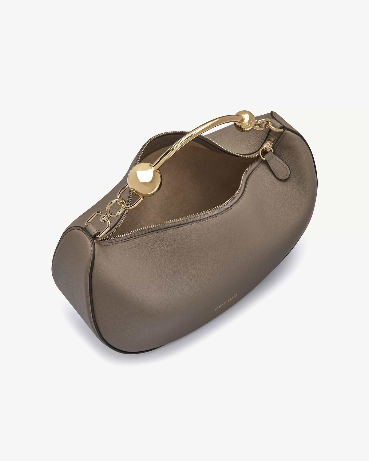 Taupe crescent moon bag with gold chain handle and visible Strathberry logo.