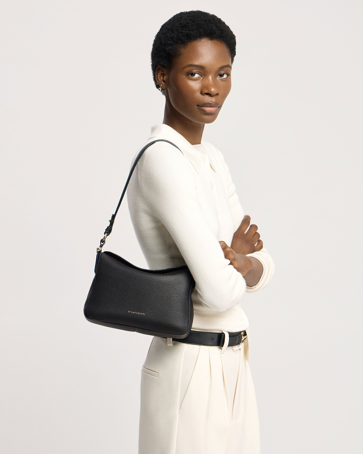 Model wearing a black Sway shoulder bag with visible Strathberry logo.
