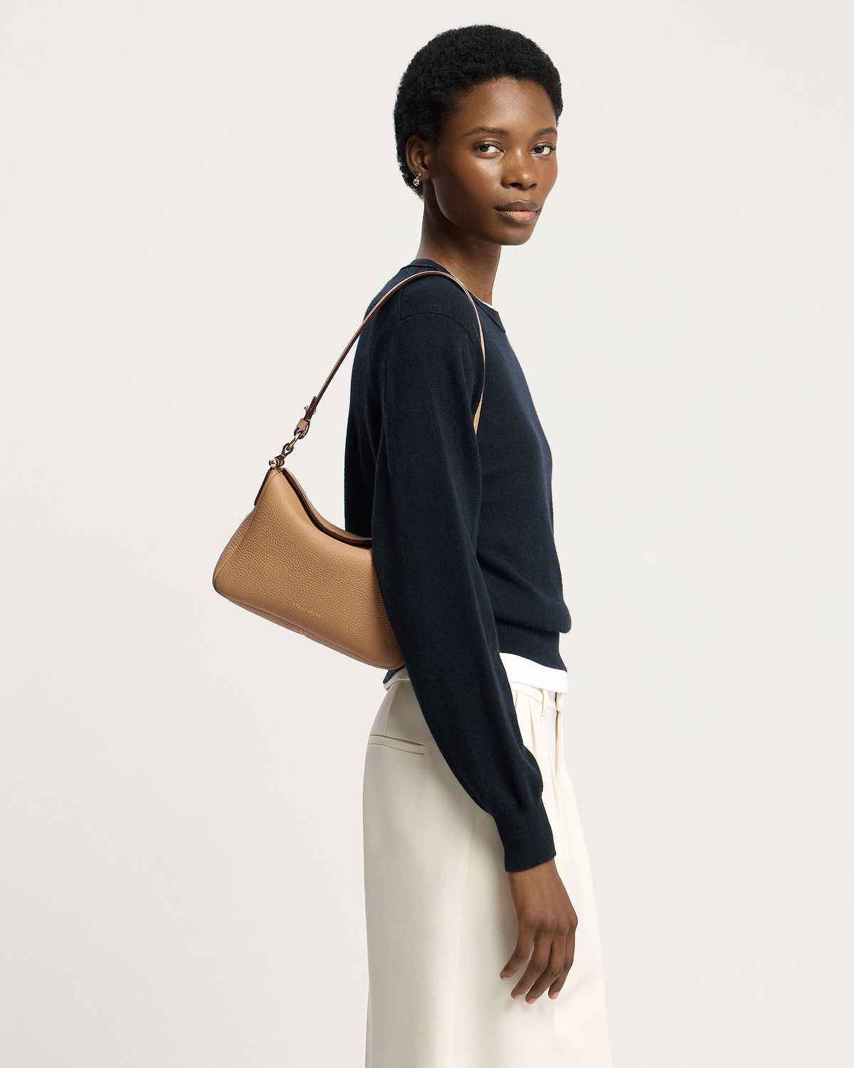 Model wearing a caramel Sway leather shoulder bag over her shoulder.