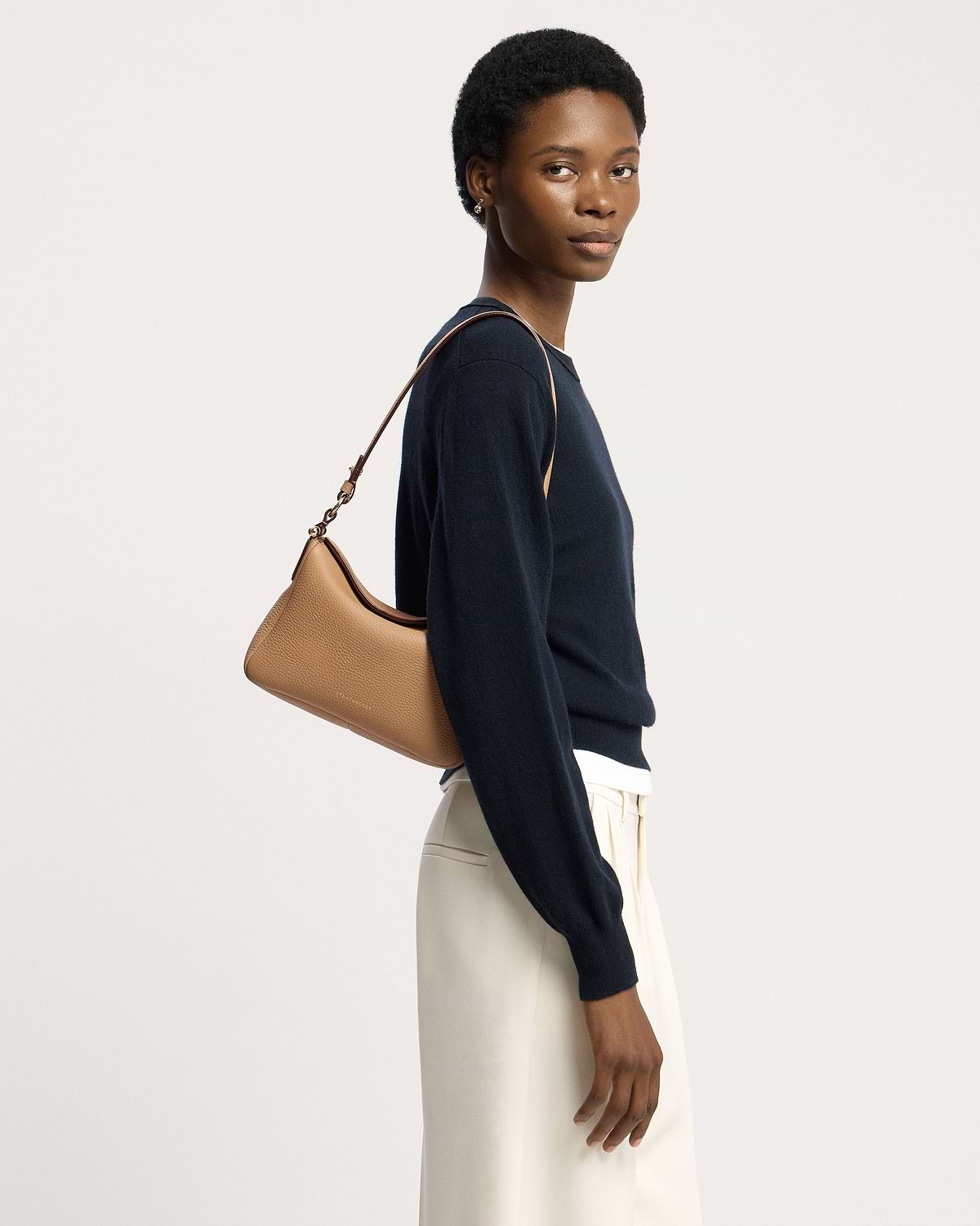 Model wearing a caramel Sway leather shoulder bag over her shoulder.