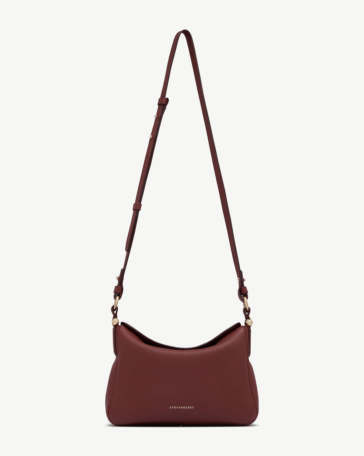 Strathberry Sway oxblood leather shoulder bag with adjustable strap and gold hardware.