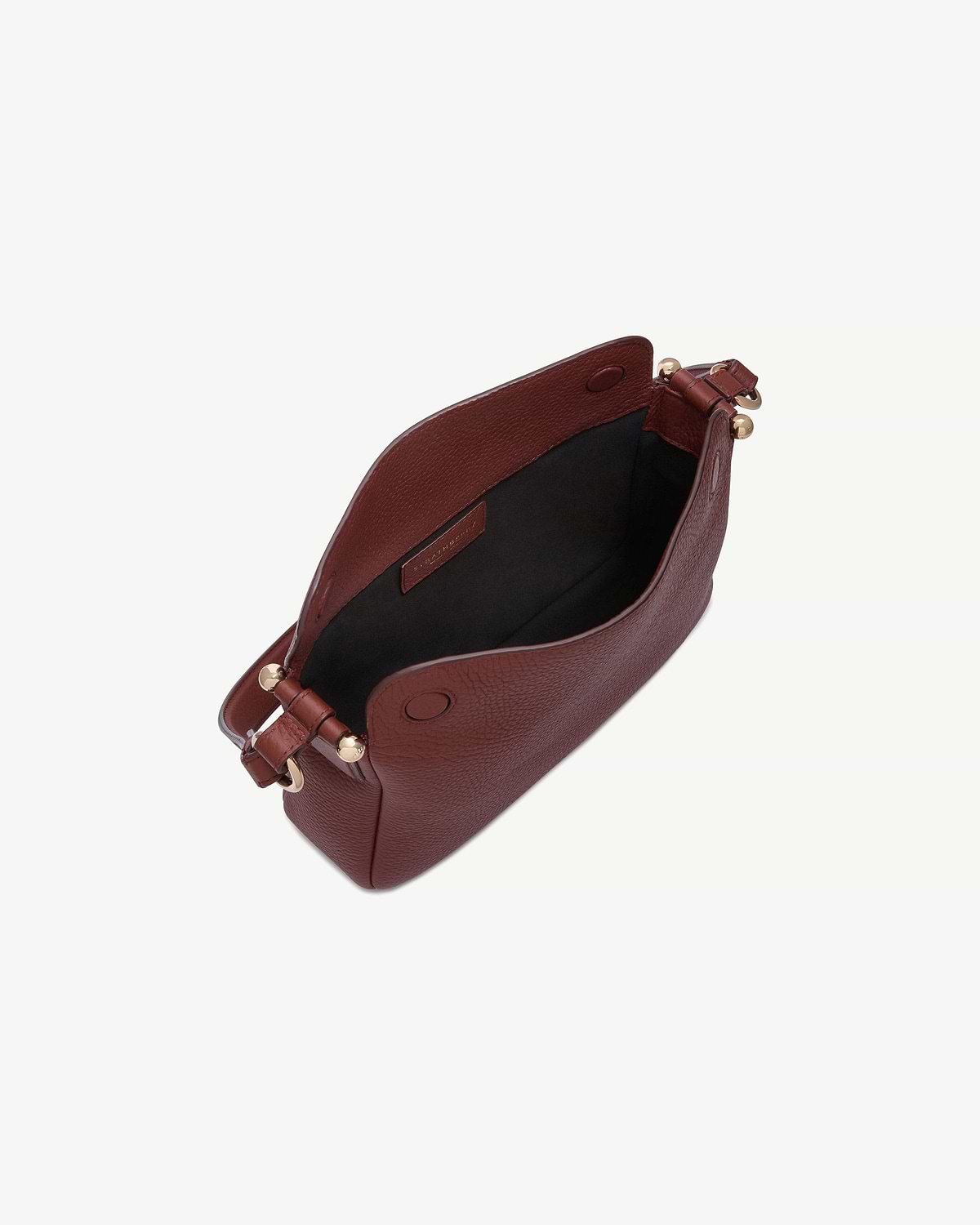 Strathberry Sway bag in oxblood, open top showing black lining and gold hardware.